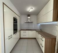 A kitchen in a 4-room apartment with light cabinets and tiled flooring.