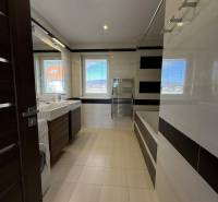 Bathroom in a 4-room apartment with a bathtub, sinks, and a washing machine.