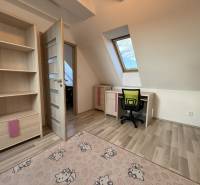 A room in a 4-room apartment with a wooden decor floor and an office corner.