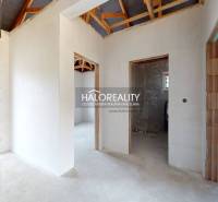 The interior of a family house with unplastered walls and visible roof structure.