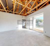 Interior of a family house with an exposed ceiling and large glass doors.