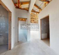 An unfinished interior of a family house with a wooden roof structure and open rooms.