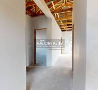 Interior of a family house with a roof structure and white plastered walls.