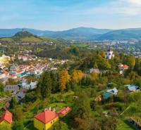 Aerial view of residential plots in Banská Štiavnica, with a view of the landscape.