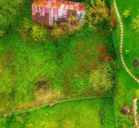 Aerial view of a residential plot in Banská Štiavnica with greenery and a walkway.