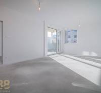 Empty bright space in a 3-room apartment with a window and balcony doors.