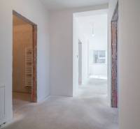 A hallway in a 3-room apartment with a large window and unfinished doors.