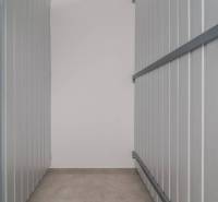 Storage space with metal walls, floor with wood decor in a 3-room apartment.