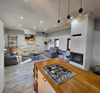 Interior of a family house with a fireplace and kitchen, floor with wooden decor.