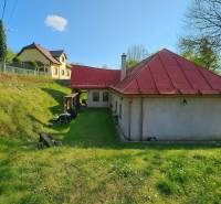 A family house in Štiavnické Bane on Štiavnické Bane street with a red roof on the grass.
