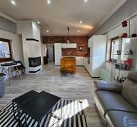 Living room in a family house with a fireplace, wooden decor, and seating sets.