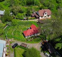 Aerial view of a family house in Štiavnické Bane surrounded by greenery and neighboring houses.