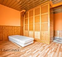 Interior of a family house with a wooden decor floor, a mattress, and a built-in wardrobe.