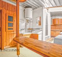 A kitchen in a family house with wooden paneling and practical equipment.