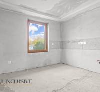 Unused room with a concrete floor and a window in a family house.