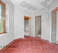 A family house with red tiles, plastered walls, and three open passages.