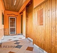 A hallway in a family house with wooden paneling and a tiled floor.