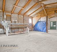 A room being renovated in a family house with a sloped ceiling and building materials.