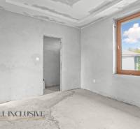 Interior of a family house with unfinished walls and a large window.