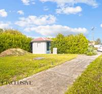 A yard at a family house in Bátorove Kosihy with a lawn and a garden shed.