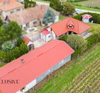 Aerial view of a family house in Bátorove Kosihy with a red roof and a garden.