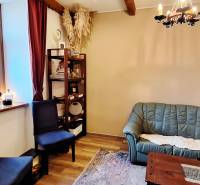Commercial space with a green sofa, shelves, and a wooden decor floor.