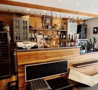 Commercial premises with a wooden bar and wines, floor with wooden decor, decorative elements.