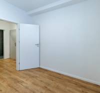 A room in a 3-room apartment with a wooden decor floor and white walls.