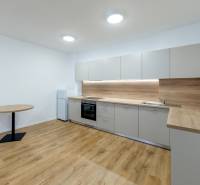 A kitchen in a 3-room apartment with a kitchen unit and a floor with a wooden decor.
