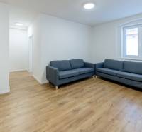 Living room with a blue sofa and a wooden decor floor in a 3-room apartment.