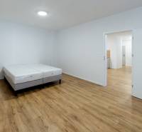 Bedroom in a 3-room apartment with a bed and a wooden decor floor.