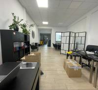 Commercial space with shelves, tables, chairs, and flooring with a wooden decor.