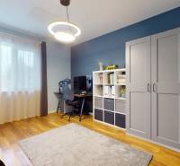 A room in a family house with a writing desk, a shelf, and a floor with a wooden decor.