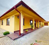 A family house on Ďatelinová Street in Iža with a landscaped yard and climbing plants.