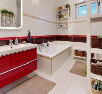 A bathroom in a family house with a bathtub, a sink, and storage baskets.