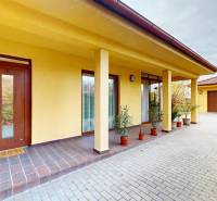 A family house on Ďatelinová Street in Iža with a garage and an arcade, surrounded by greenery.