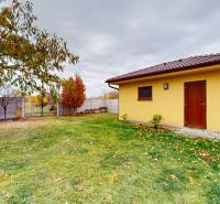 A garden at a family house on Ďatelinová Street in Iža with a wooden shelter in the yard.