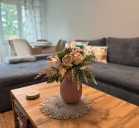 A comfortable living room in a two-room apartment with a sofa and flowers on the table.