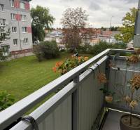 The balcony of the green 2-room apartment in Sereď with a view of greenery and the neighboring house.