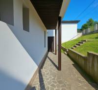 A walkway to a family house in Banská Štiavnica, Hájik, bordered by a grassy slope.
