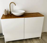 Sink on a wood-decor countertop, white cabinet, and floors with wood decor.