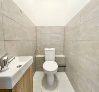 A restroom with gray tiles and a sink in the office.