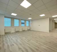 Spacious offices with wood-patterned flooring and white walls.