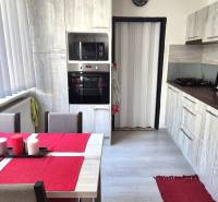 A kitchen with a dining table, white blinds, and a kitchen unit in a 2-room apartment.