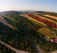 Hilly landscape with agricultural and forest lands in the Rokycany district, road along the forests.