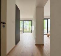 A bright interior of a two-room apartment with wooden flooring and large windows.