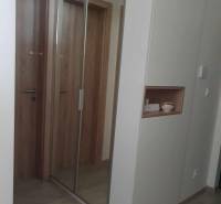 A hallway with a large mirror and a floor with a wooden decor in a 2-room apartment.