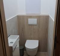 A toilet with a wooden floor decor in a 2-room apartment, simple design.