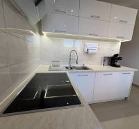 Elegant kitchen in a 3-room apartment with white cabinets and an induction cooktop.
