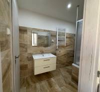 A bathroom in a 3-room apartment with light tiles and a hanging cabinet.